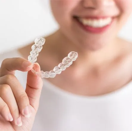 woman holding clear aligner